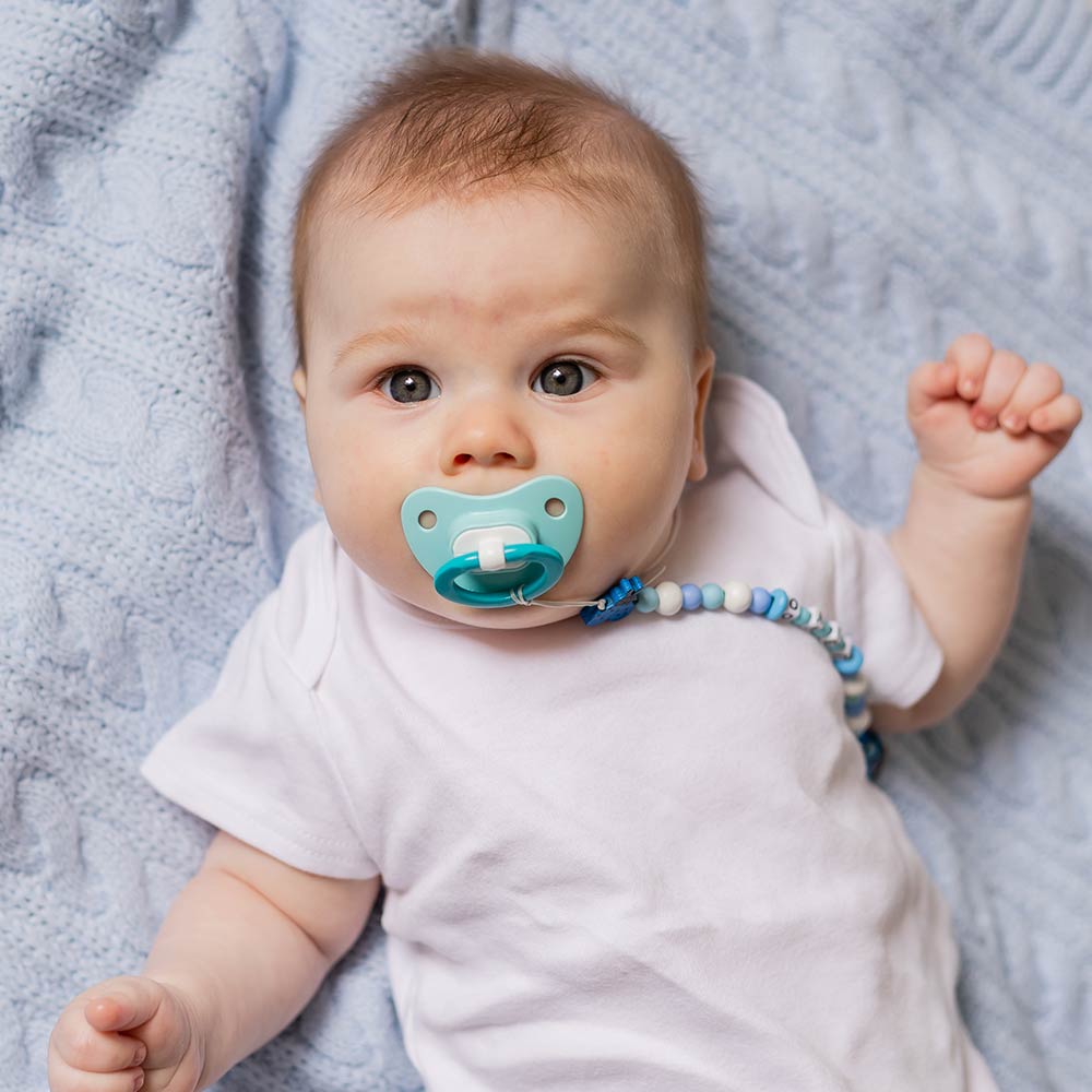 Ein Baby hat einen Schnuller im Mund